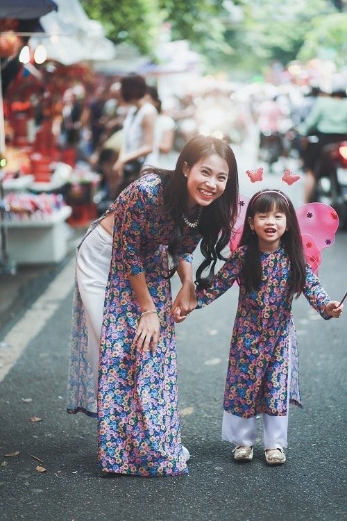 柄の入ったアオザイを着たベトナム人女性と子供